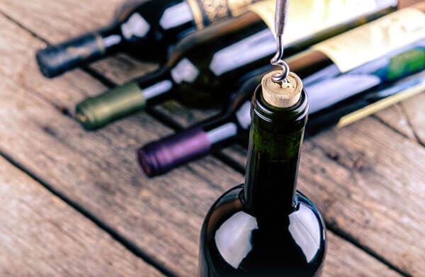 A corkscrew opening a wine bottle